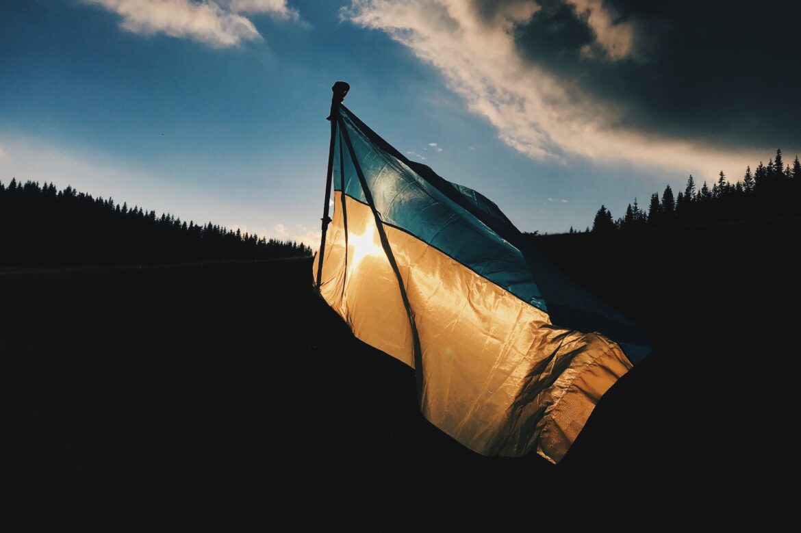 An image of a Ukraine flag with mountains in the background